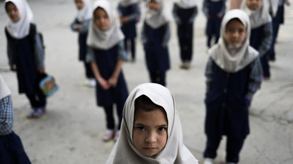 Avganistan: „Nastavićemo pogubljenja i odsecanje delova tela" - poručuje jedan od talibanskih vođa 2 Afghan girls look on at a school in Kabul, Afghanistan
