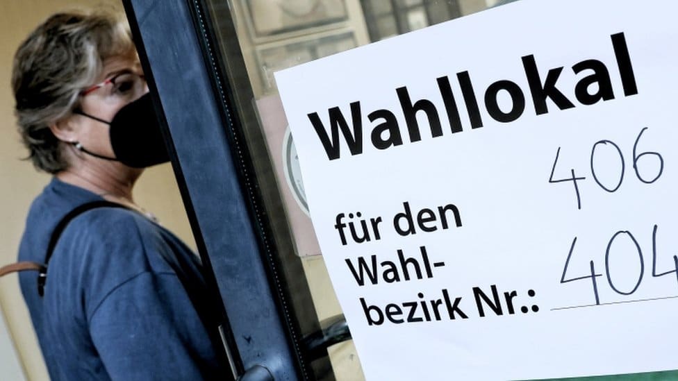 Nemačka i izbori: Tesna trka između socijaldemokrata i konzervativaca 4 A woman enters a polling station to vote in the German general elections in Berlin, Germany, early 26 September 2021.