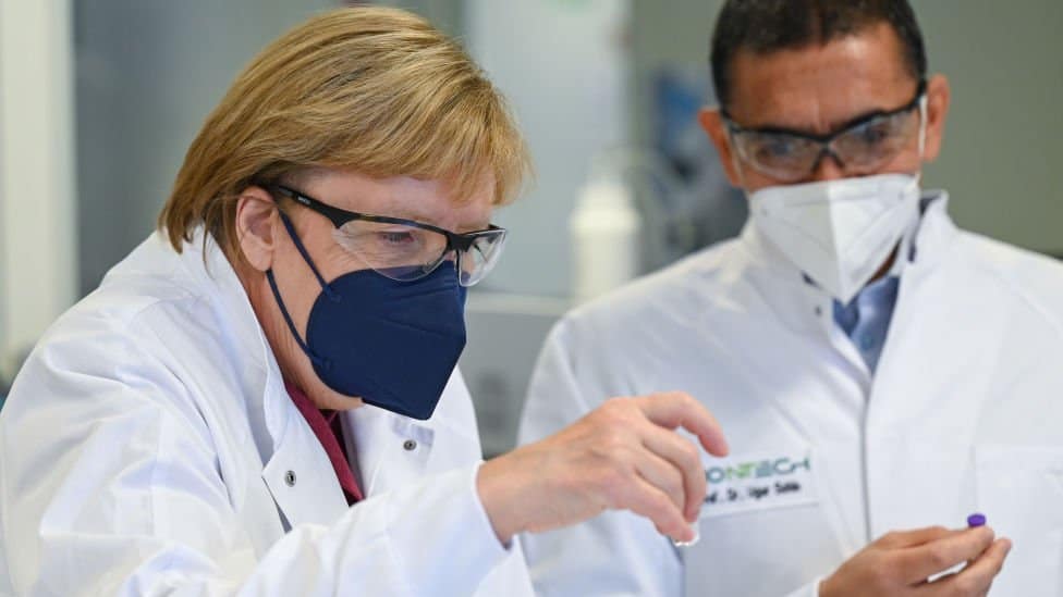 Ugur Sahin, osnivač i izvršni direktor biotehnološke kompanije BionTek pokazuje Angeli Merkle ampulu Fajzer vakcine u Marburgu