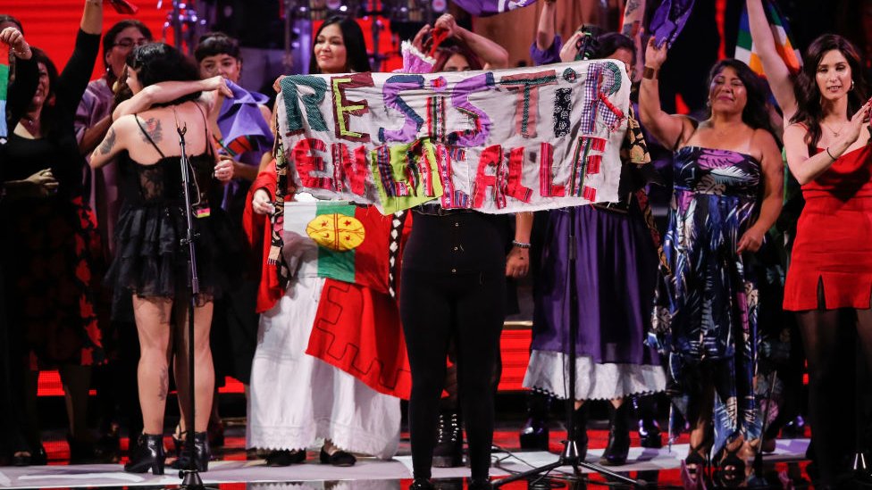 Singers with Chilean artist Mon Laferte show a banner reading 'Resist on the Street' at a concert last year