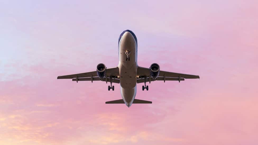 An aeroplane lands in a beautiful sunset