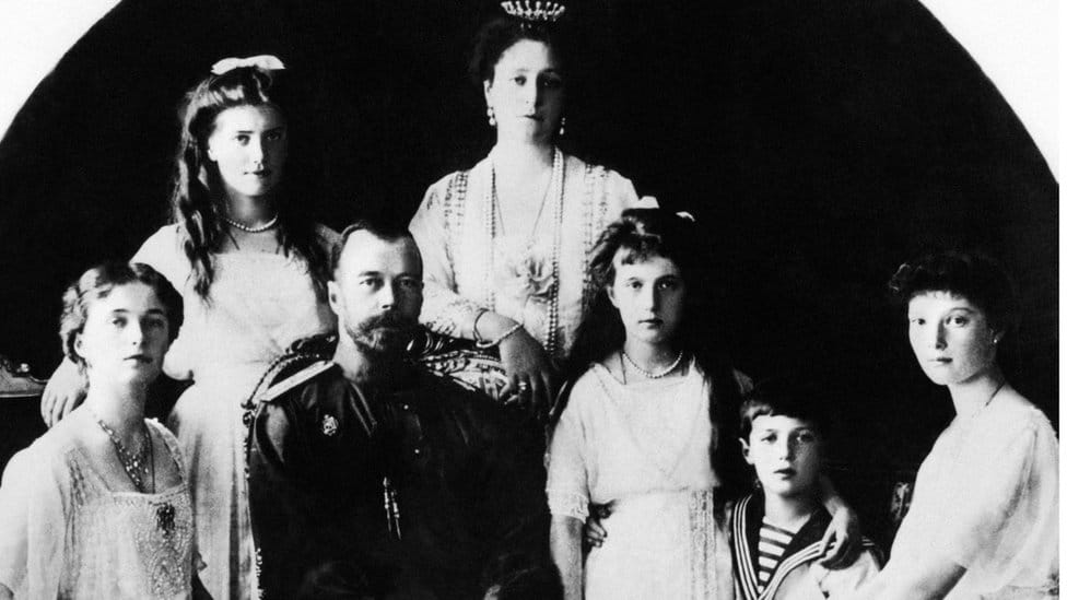 Tsar Nicholas II sits with his family - his wife, Tsarina Alexander, leans on the back of his chair and his children sit around him