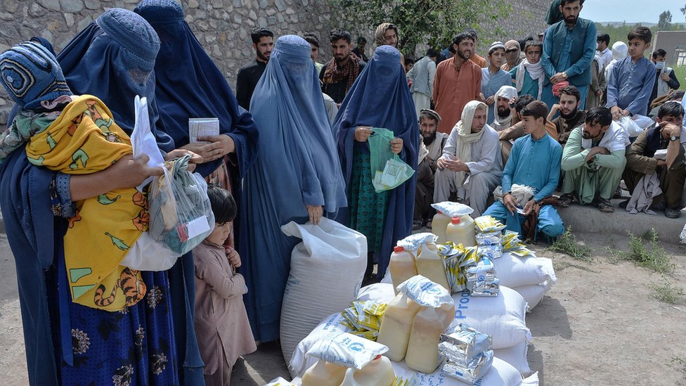 Afghan women receive food donations as part of the World Food Programme (WFP) for displaced people, during the Islamic holy month of Ramadan in Jalalabad on April 20, 2021
