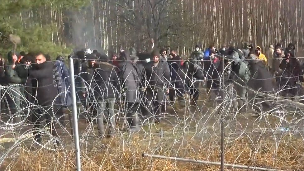 Migranti, Belorusija i Poljska: Stotine migranata na granici Belorusije i Poljske, Varšava strahuje od „oružane eskalacije" 4 A migrant attempts to break through the barbed wire on Poland's border with Belarus