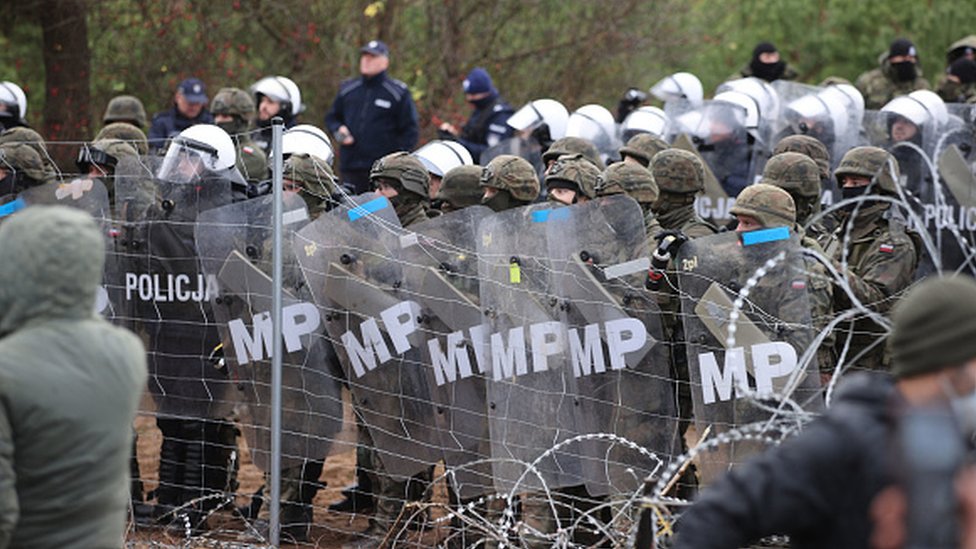 Migranska kriza u Evropi: Napetosti na poljsko-beloruskoj granici splase, migranti na toplom u privremenom skloništu 14 Polish troops and border guards with shields stop migrants from crossing into the country