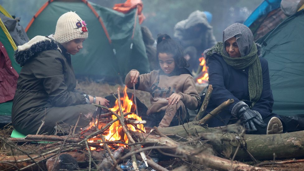 Migrants gather near a fire on the Belarusian-Polish border