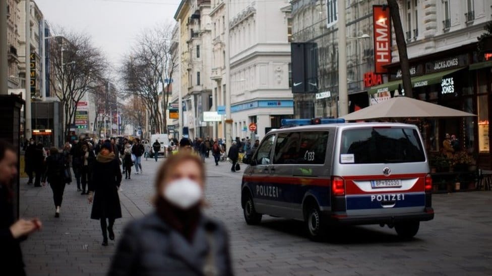 Korona virus i Austrija: Kako se nevakcinisani privikavaju na stroge mere 1 A police car is seen as pedestrians walk along a shopping street after the Austrian government placed roughly two million people who are not fully vaccinated against the coronavirus disease (COVID-19) in lockdown