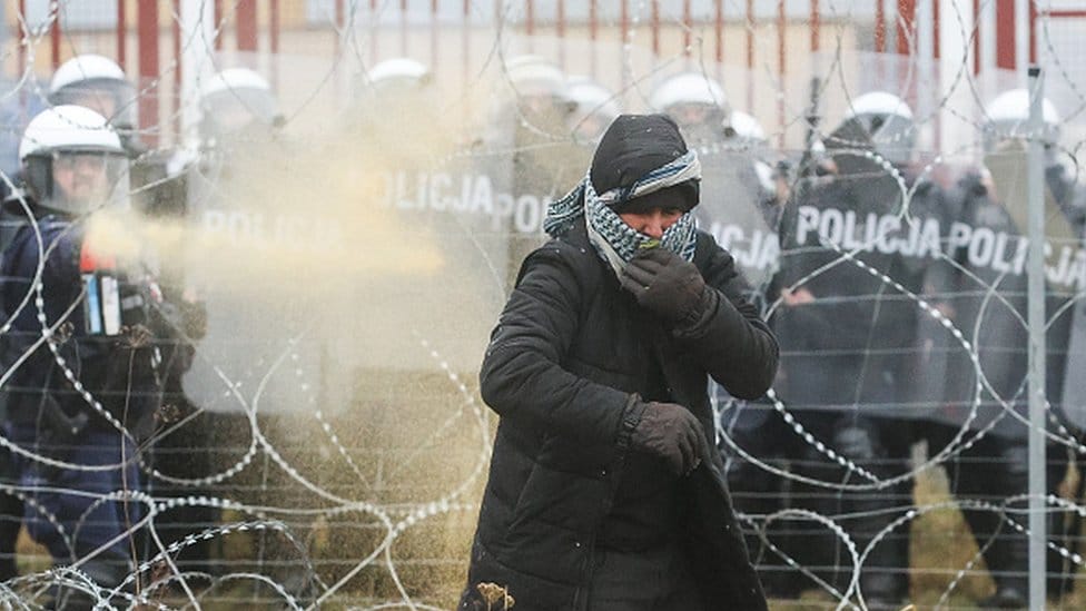 Migranska kriza u Evropi: Napetosti na poljsko-beloruskoj granici splase, migranti na toplom u privremenom skloništu 2 Polish riot police officers and a migrant are seen near the Kuznica crossing point