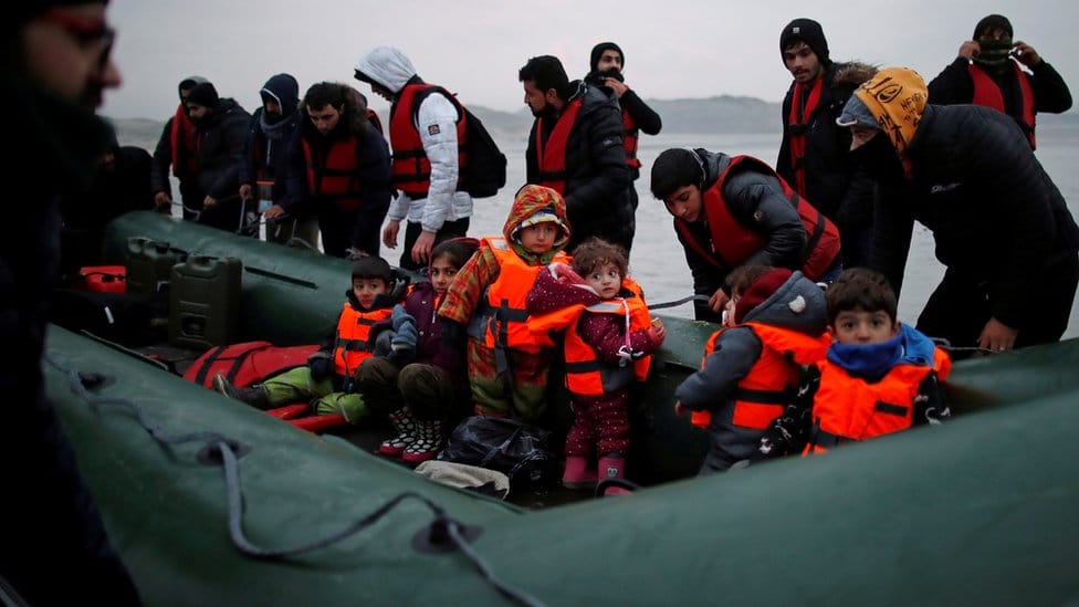 A group of more than 40 migrants with children get on an inflatable dinghy, as they leave the coast of northern France to cross the English Channel, near Wimereux, France,