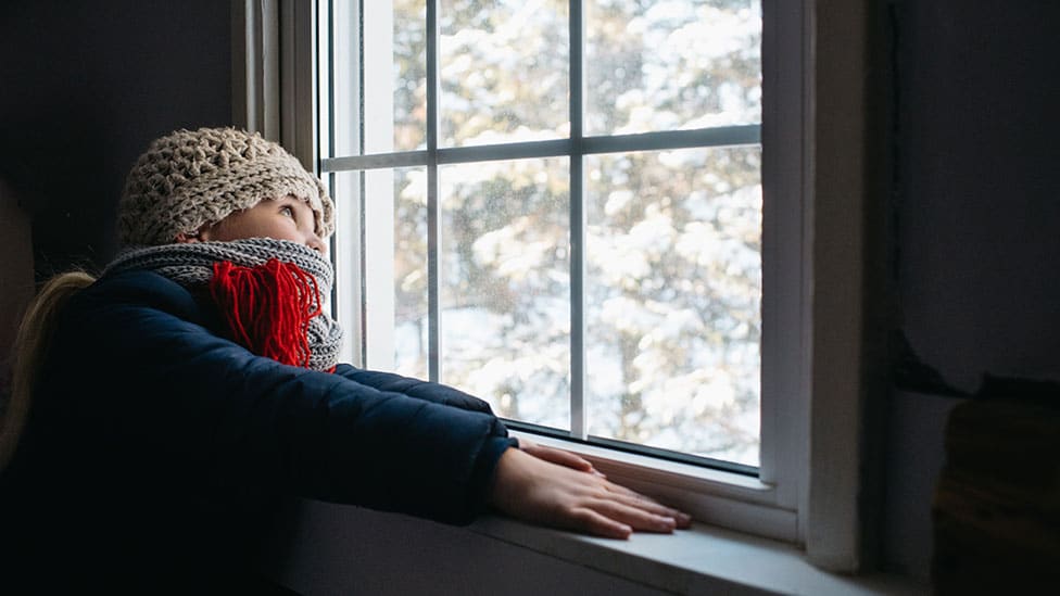 Zima i saveti: Četiri jeftina načina da uštedite energiju kod kuće 1 Girl looks out of window on cold day