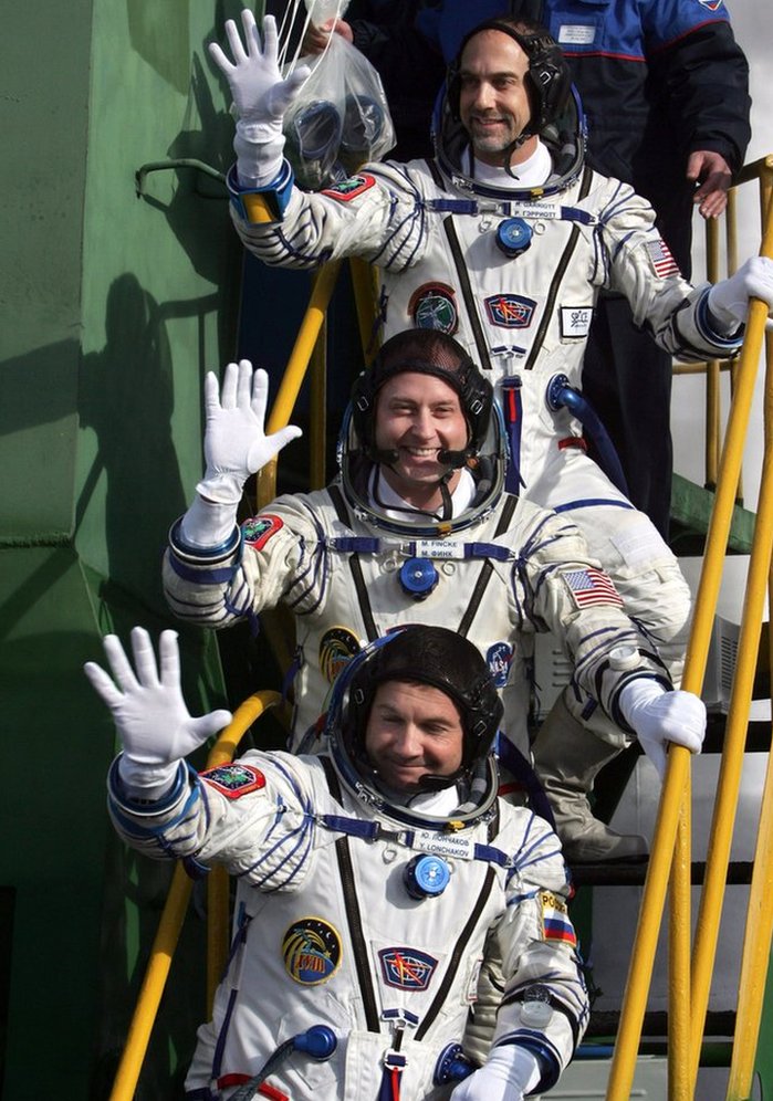 Svemirski turizam: Mali korak za dobrobit čovečanstva ili veliki korak za štetu po životnu sredinu 3 Russian cosmonaut Yury Lonchakov (bottom), US astronaut Michael Fincke (centre) and his compatriot, space tourist Richard Garriott (top), wave as they board the spacecraft at the Baikonur cosmodrome, in Kazakhstan, on 12 October, 2008.