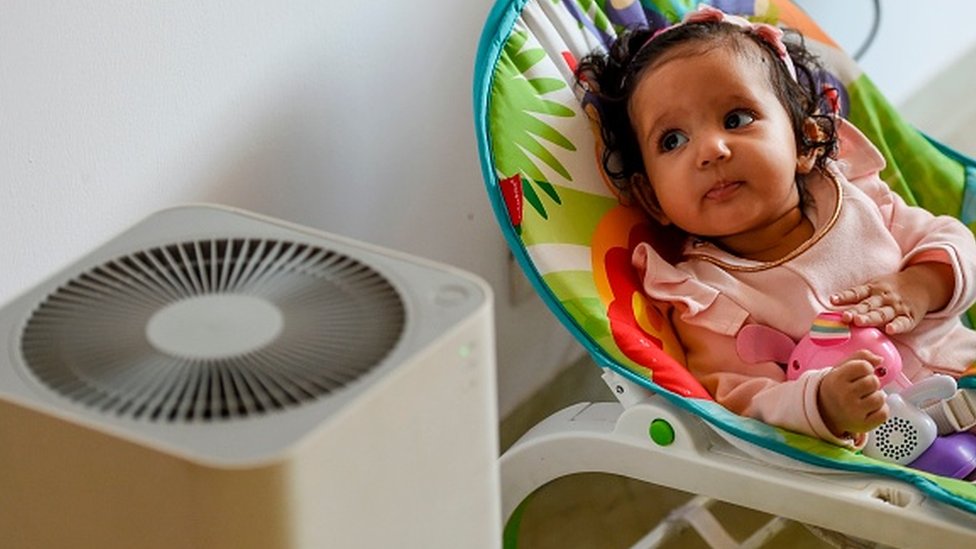 Ekologija i Indija: U Delhiju vazduh zagađeniji unutra nego napolju 1 A baby rests near an air purifier at her residence in New Delhi.