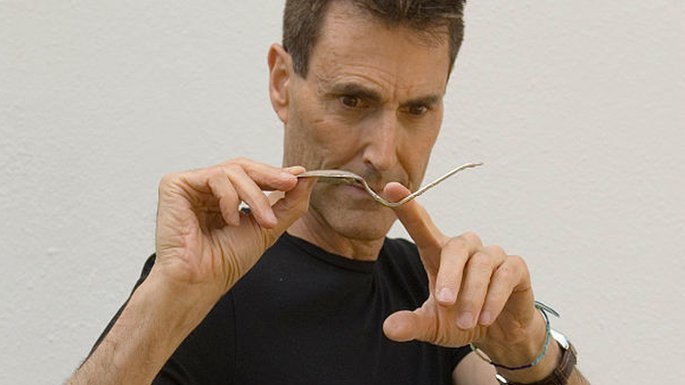 Uri Geller holding a bent spoon