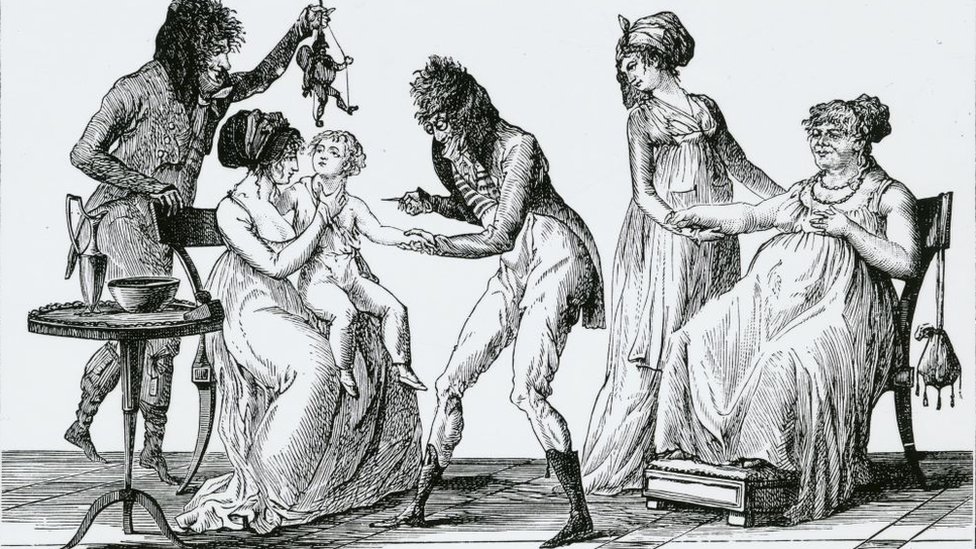 Korona virus i vakcina: Kako su antivakcinaši vršili uticaj na svet kroz istoriju 7 A drawing showing inoculation of a child taking place while they are distracted by a marionette