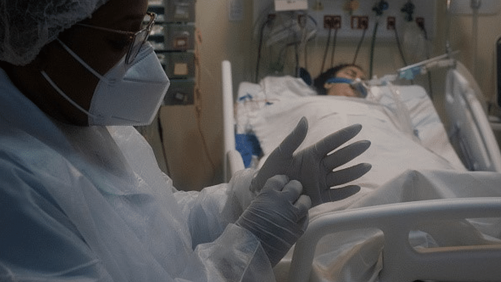 A healthcare professional takes care of a patient who is on a respirator