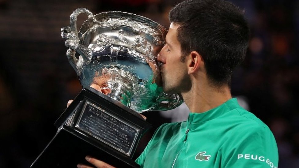 Novak Đoković i tenis: Australijanci ljuti - „Baš me briga koliko je dobar - ako neće vakcinu, ne treba mu dati da dođe" 1 Novak Djokovic kisses a trophy he was awarded for winning last year's Australian Open title