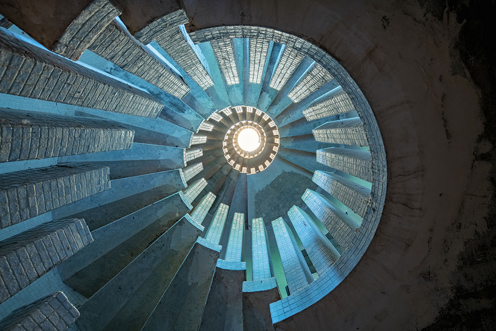 A view upward at a concrete staircase in an abandoned manor in Wimbledon, UK