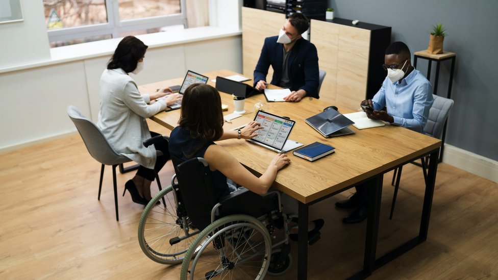 Korona virus i omikron soj: Koliko je dugo zarazan neko sa kovidom 4 Co-workers wear face masks in an office