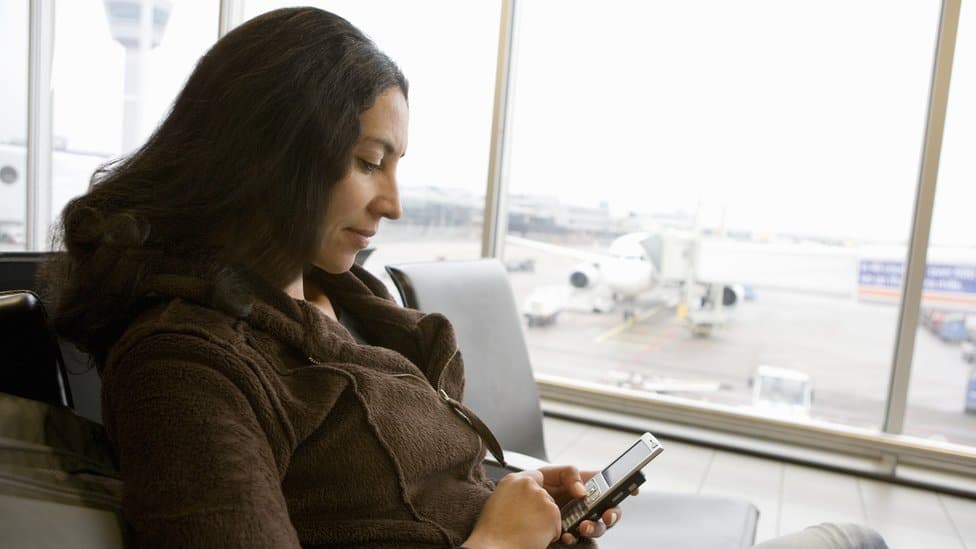 5G mreža i avio-saobraćaj: Koliko je velika opasnost za letove u Americi 1 A woman using her phone at an airport