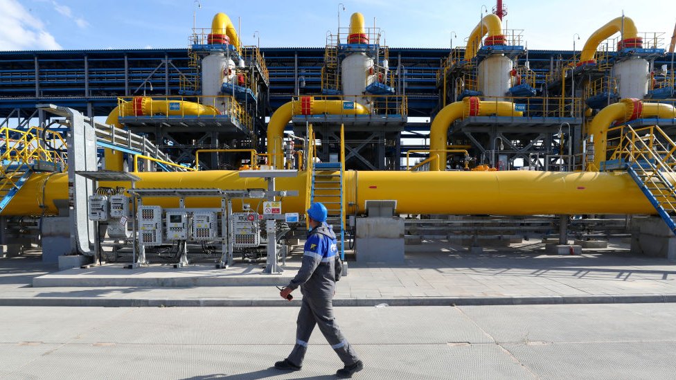 Ukrajinska kriza: Kakve sankcije Zapad uvodi Rusiji i kakav je odgovor Moskve 2 A worker walking pass by an output filtration facility of a gas treatment unit at the starting point of the Nord Stream 2 offshore natural gas pipeline