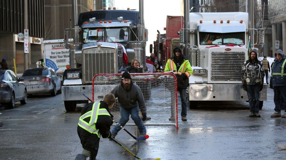 Korona virus i Kanada: Zbog blokade ključnog prelaza sa Amerikom prekinuta proizvodnja u nekim automobilskim gigantima 2 Protesters play street hockey as trucks block a street in downtown Ottawa
