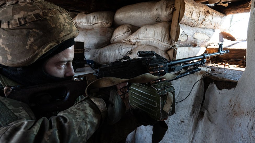 Ukrajinska kriza: Još nisu iscrpljene sve diplomatske mogućnosti, kažu lideri Rusije, SAD i Velike Britanije 1 A Ukrainian serviceman points a machine gun through an opening in a sandbag bunker during military exercises