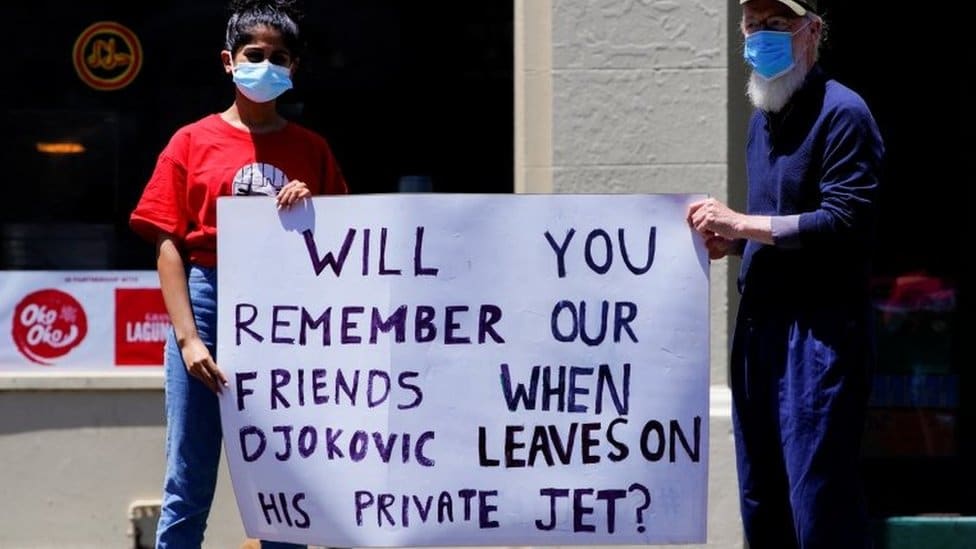 Australija i migranti: Tražioci azila u proseku provedu 689 dana u pritvoru 2 Refugee activists hold a sign reading: 'Will you remember our friends when Djokovic flies out on his private jet'