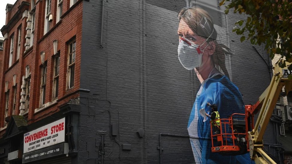 Korona virus, Evropa i svet: Dok Engleska ukida sve mere, kako je u drugim zemljama 6 An artist creates a mural of a National Health Service worker on a wall in north Manchester on 17 October 2020, as the number of cases of the novel coronavirus COVID-19 rose.