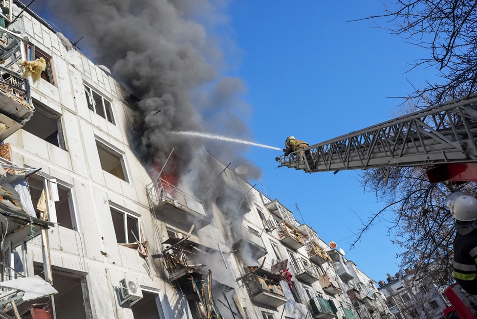 Ruski napad na Ukrajinu u fotografijama 3 Ukrainian firefighters try to extinguish a fire after an airstrike hit an apartment complex in Chuhuiv, Kharkiv Oblast, Ukraine on 24 February 2022