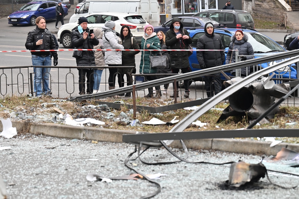 Ruski napad na Ukrajinu u fotografijama 8 People react standing behind the cordoned off area around the remains of a shell in Kyiv on 24 February 2022