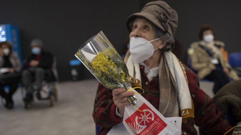 Međunarodni dan žena i Srbija: Godina kada su žene progovorile 7 A woman receives mimosa flowers at a vaccination hub in Rome, Italy on International Women's Day 2021.