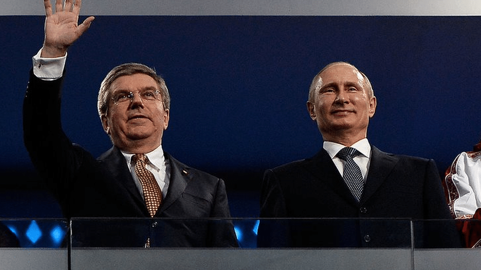 Ukrajina i Rusija: Kako sportski svet reaguje na rat u Ukrajini 6 IOC president Thomas Bach (left) waves to the crowd alongside Russian president Vladimir Putin during the Sochi Winter Olympics in 2014