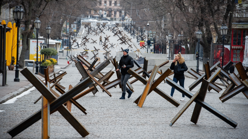 Ukrajina i Rusija: Da li će ključna luka Odesa biti sledeća ruska meta 4 People walking in the street among dozens of anti-tank weapons.