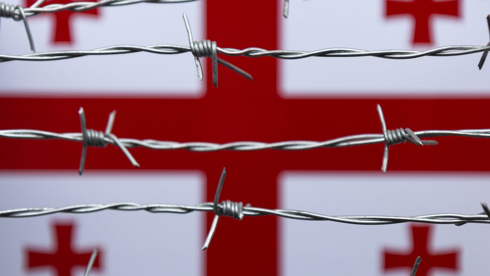 Gruzinskiй flag na fone kolюčeй provoloki - stokovoe foto