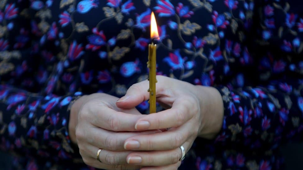 Srbija, običaji i tehnologija: Aplikacija eČitulja - hoće li Beograđani izjavljivati saučešće i slati cveće iz fotelje 1 A woman holds a candle at a memorial in Ukraine