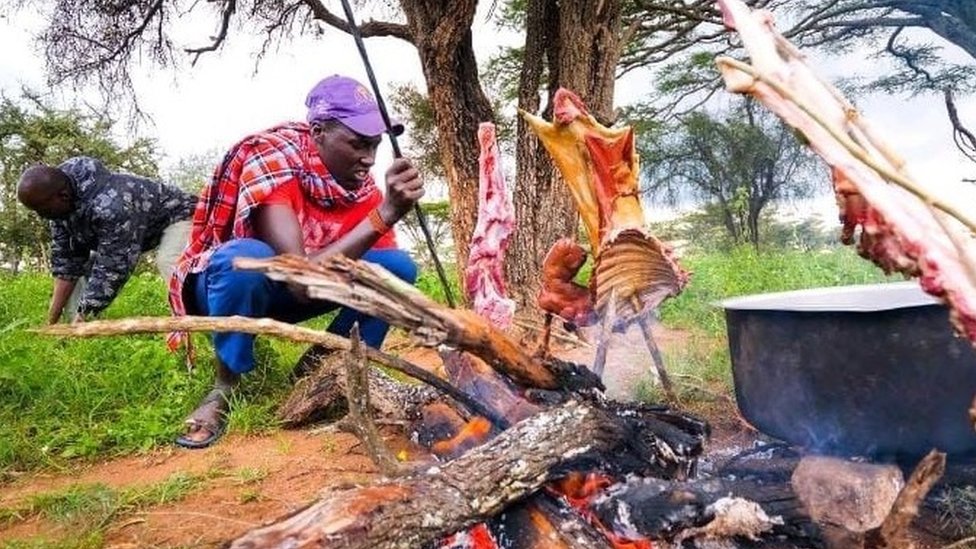 Massai man preparing meat