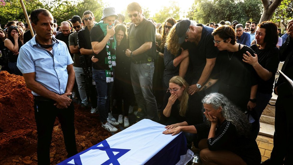 Friends and relatives mourn at the side of the coffin of Eytam Magini, who was killed during an attack by a Palestinian gunman on a bar in Tel Aviv, during his funeral in Kfar Saba, Israel (10 April 2022)