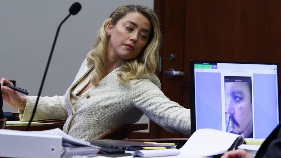 SuđenjeDžoni Dep i Amber Herd: Šta ste možda propustili ove nedelje 2 Actress Amber Heard listens to her ex-husband Johnny Depp, as a picture of an injury to his face is seen on a screen, during his defamation trial against her at the Fairfax County Circuit Courthouse in Fairfax, Virginia, April 20, 2022