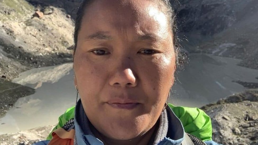 Nepal i planinarenje: Žena iz Nepala deseti put osvojila Mont Everest, postavila novi svetski rekord 1 Lhakpa Sherpa's face close-up with a mountain valley behind her