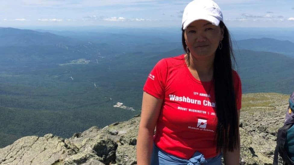 Nepal i planinarenje: Žena iz Nepala deseti put osvojila Mont Everest, postavila novi svetski rekord 4 Lhakpa Sherpa standing above a deep valley, wearing a tee-shirt with 'Mount Washington' printed on it