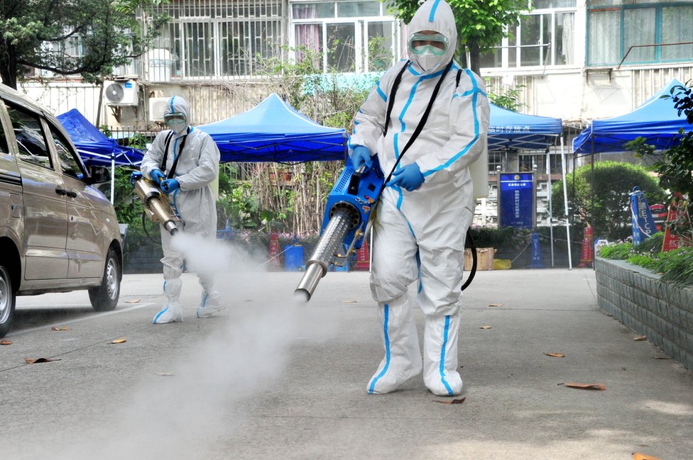 Staff members wearing personal protective equipment (PPE) disinfect a residential community on 2 May, 2022 in Shanghai, China