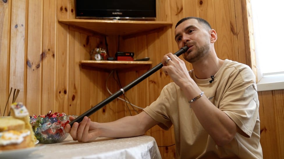 Tymofii 'Tima' Muzychuk jams in his kitchen on a traditional telynka flute.