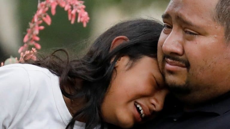 People react after the shooting outside Robb Elementary School