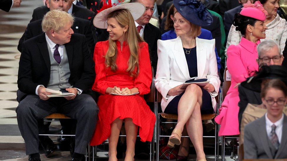 British Prime Minister Boris Johnson and his wife Carrie Johnson look at each other next to British Foreign Secretary Liz Truss as they attend the National Service of Thanksgiving
