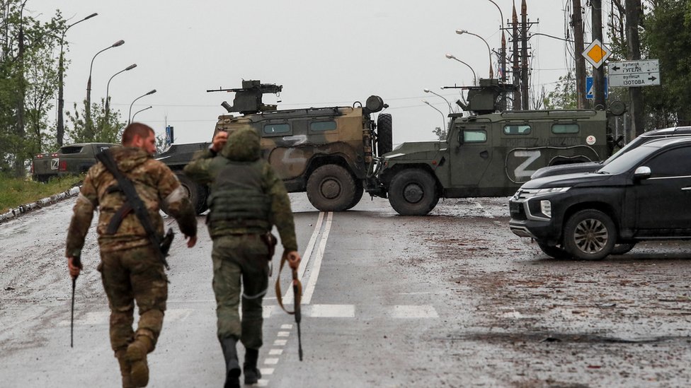 Ukrajina i Rusija: Još jedan ruski general poginuo u borbama u istočnom regionu Donbasu, navode mediji u Rusiji 1 Two Russian soldiers walk towards armoured cars