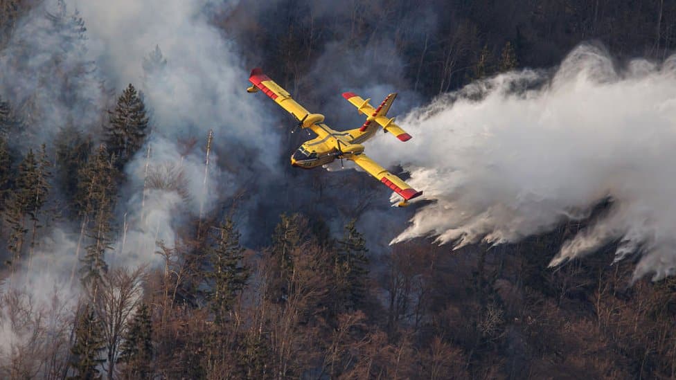 A Croatian Canadair CL-415 firefighting plane drops water on a wildfire near Preddvor, Slovenia, on 28 March 2022.