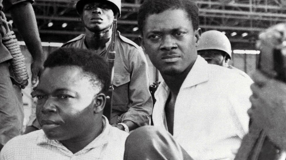 Afrika, Belgija i kolonijalizam: Sahranjen zlatni zub heroja Konga Patrisa Lumumbe - to je sve što je ostalo od njegovog tela 3 A picture taken in December 1960, shows soldiers guarding Patrice Lumumba (R), Prime Minister of then Congo-Kinshasa, and Joseph Okito (L), vice-president of the Senate, upon their arrest in Leopoldville (now Kinshasa)