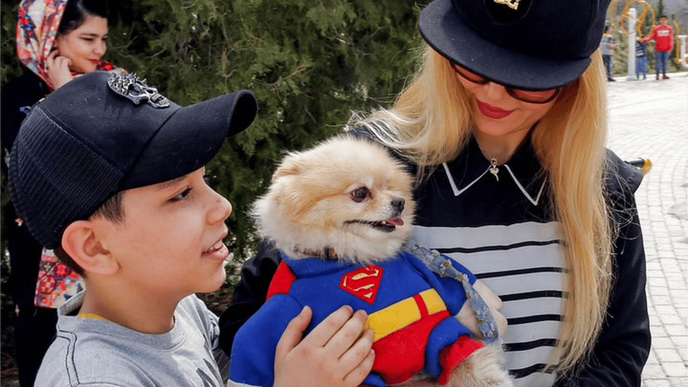 Iranska porodica sa psom obučenim u kostim Supermena
