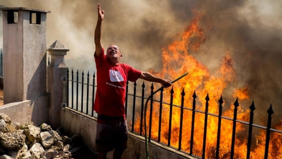 Visoke temperature: Evropa se preznojava dok se toplotni talas širi 3 Man pours water on to the flames during a forest fire in Canecas, outskirts of Lisbon, Portugal, 10 July 2022