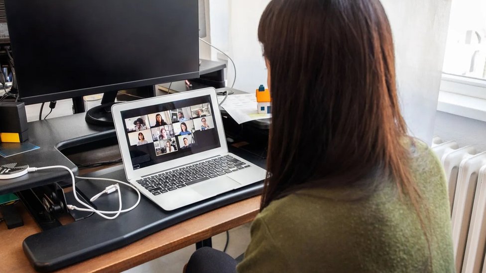 Woman takes part of video meeting in a laptop